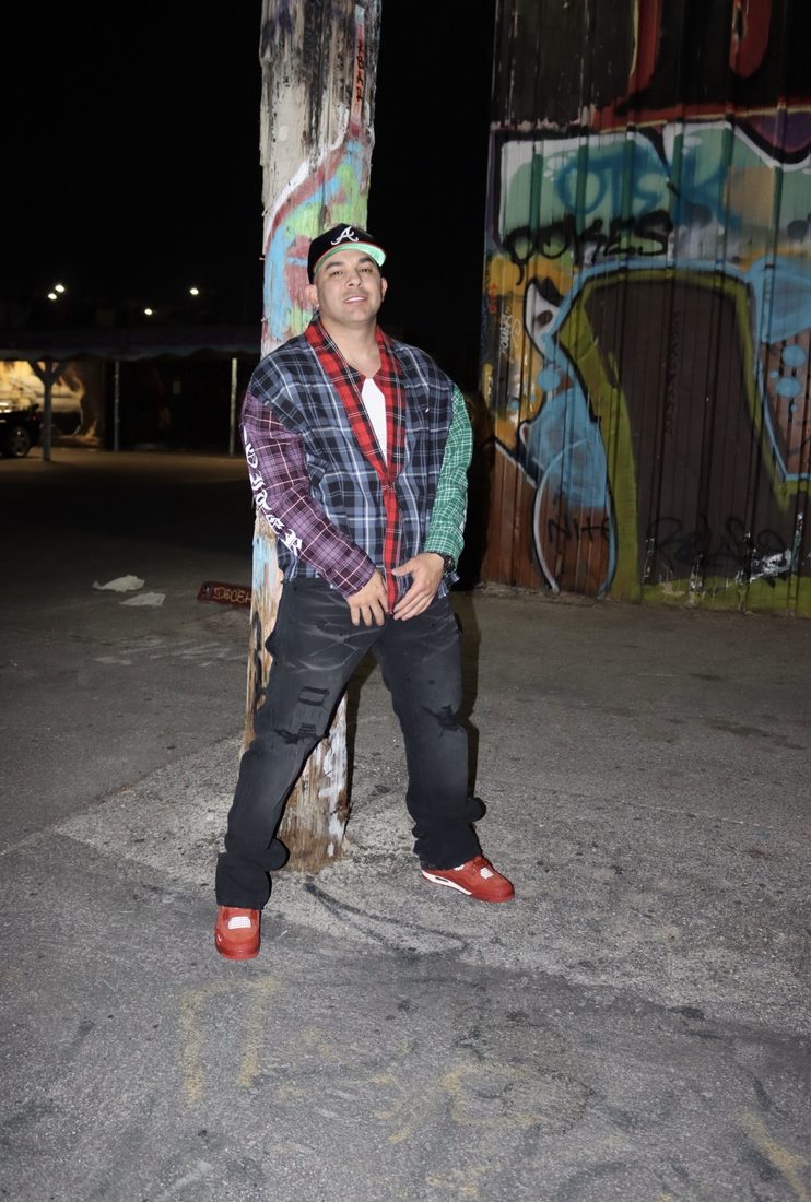 Camisa de cuadros patchwork, gorra y sneakers rojas en la calle